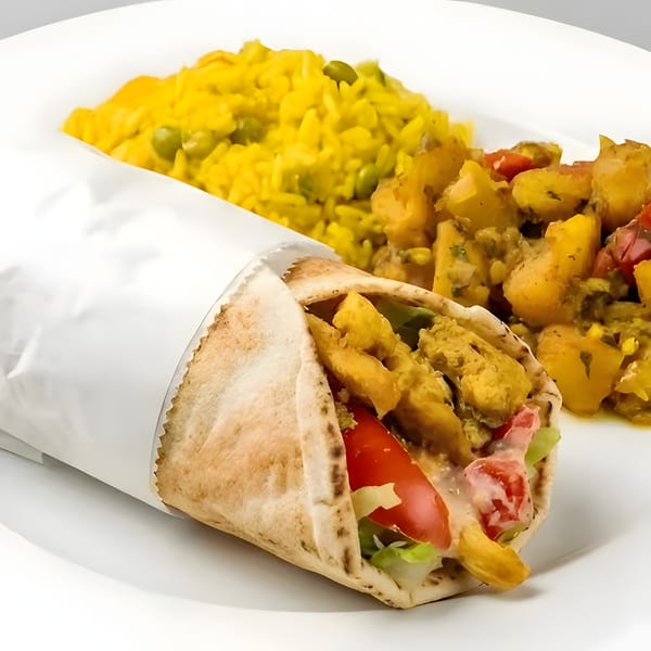 Chicken shawarma wrap with lettuce, tomatoes, and sauce, served with yellow rice and potatoes.
